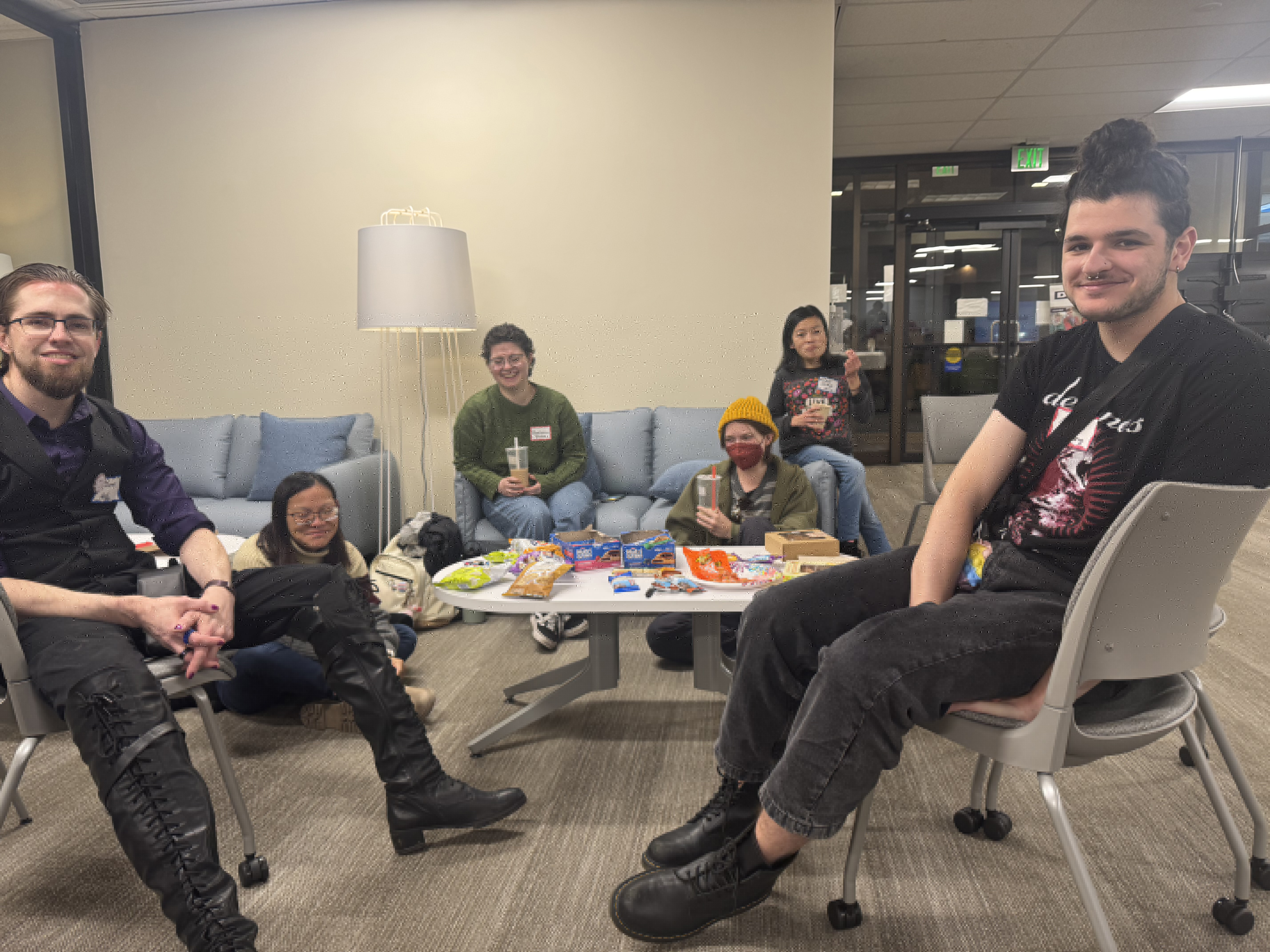 Attendees sit together laughing and eating snacks