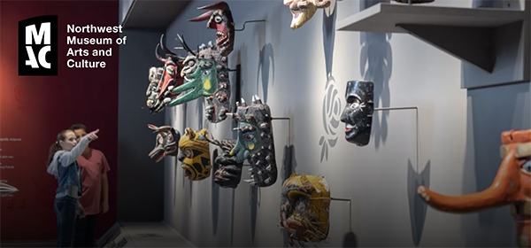 Traditional masks hang on a wall in a museum