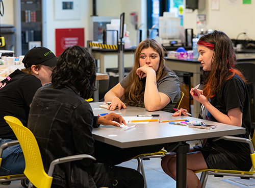 Four Scholars work on a project at the UW Makerspace, The Mill