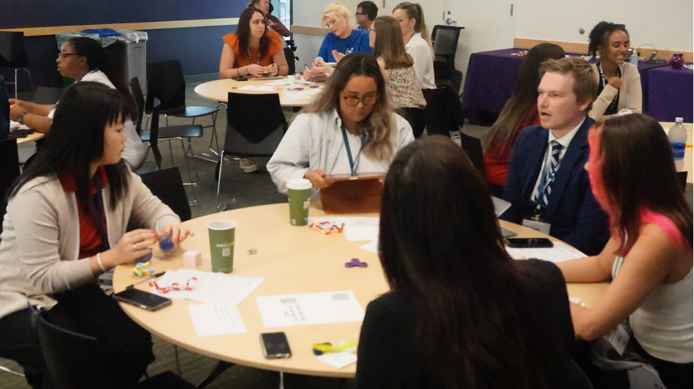 Participants talk around a table.