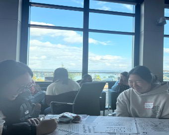 Two girls sit at a table playing a game together