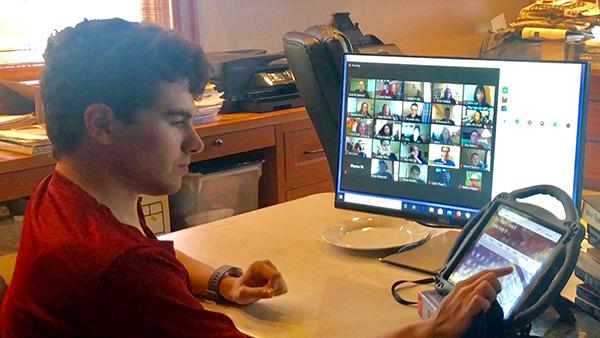 A boy using a tablet and computer